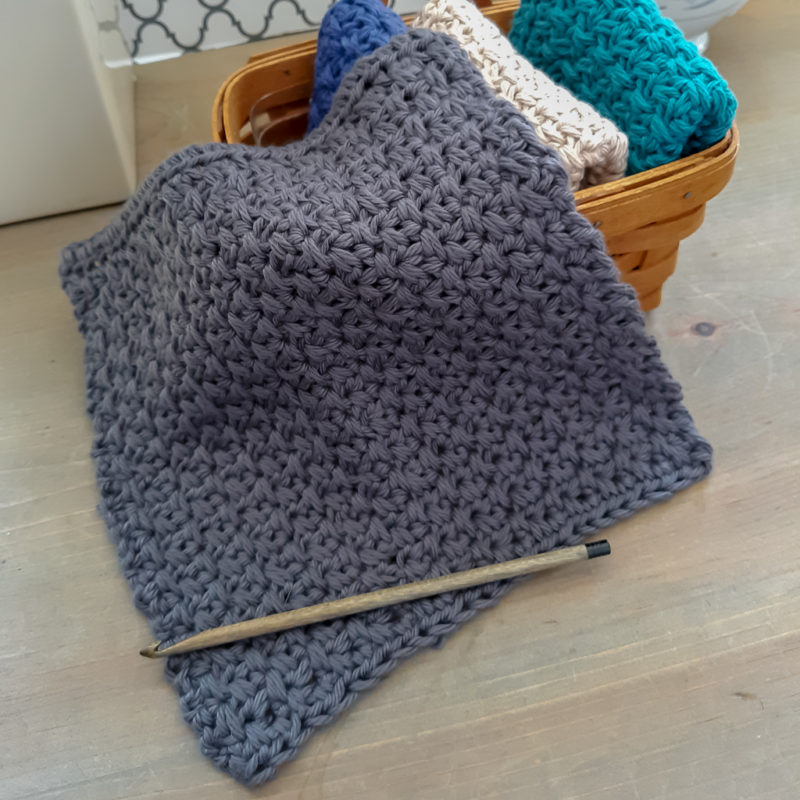 Flat lay of crochet dishcloth with wood crochet hook