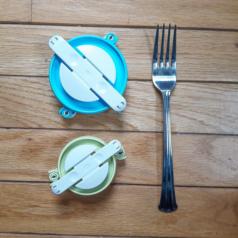 Flat lay of large and small pom pom maker and a dinner fork